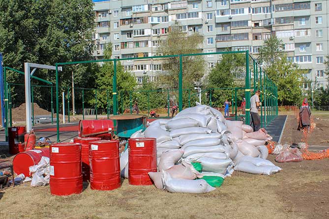 бочки и мешки около спортивной площадки