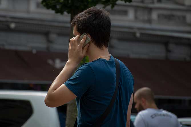 молодой человек разговаривает по мобильному телефону