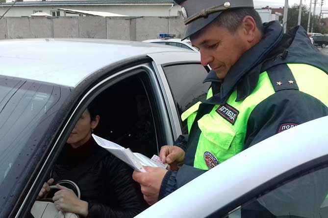 полицейский проверяет документы у женщины