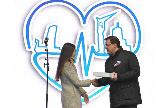 губернатор вручает приз дизайнеру логотипа единства Самарской области