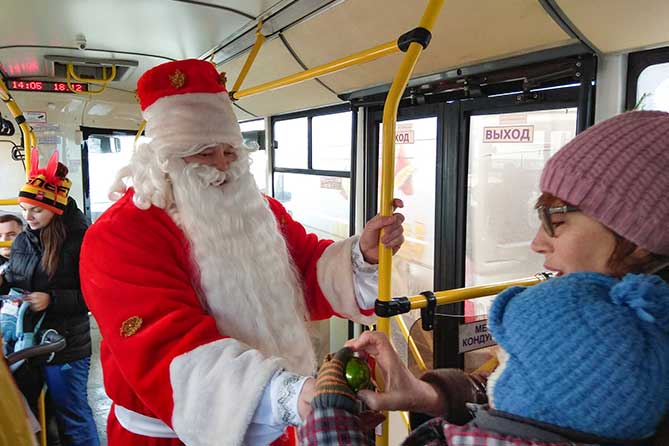 Дед Мороз поздравляет ребенка с Новым годом в автобусе