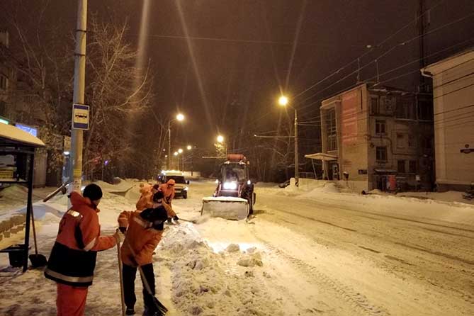 дорожные рабочие убирают снег на улице Комзина