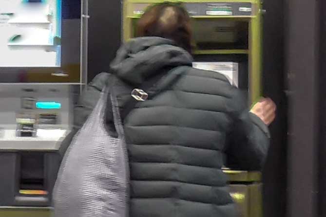 женщина стоит около банкомата