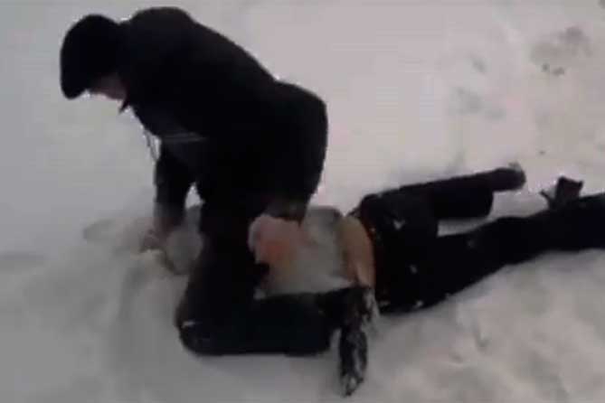 избивает человека на снегу