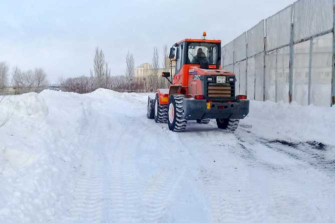 трактор рсчищает снег на стадионе "Торпедо"