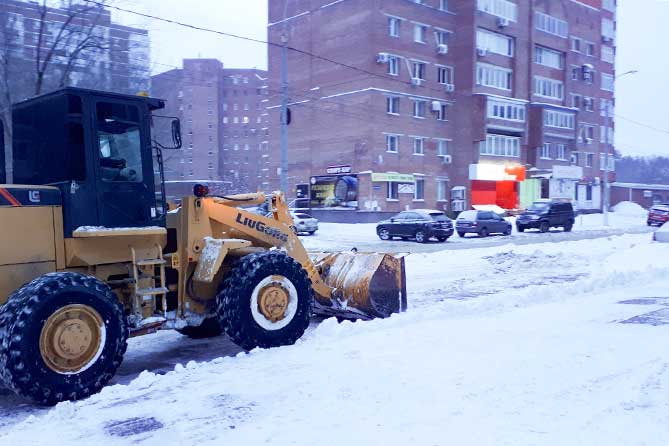 трактор чистит снег на дороге в Центральном районе