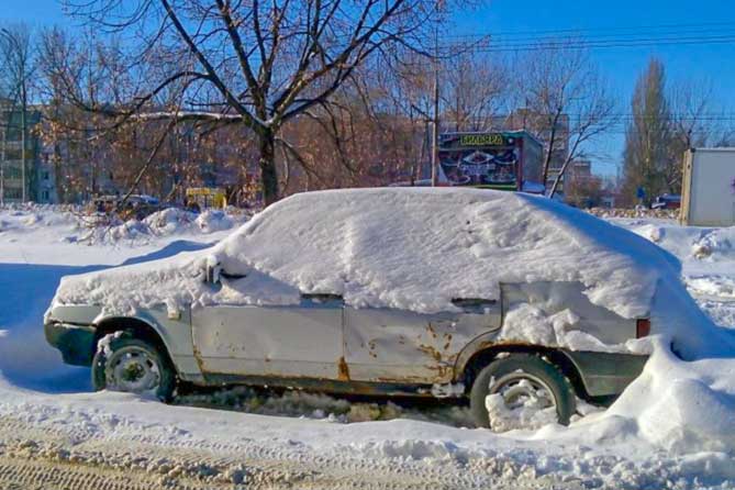брошенный автомобиль завален снегом