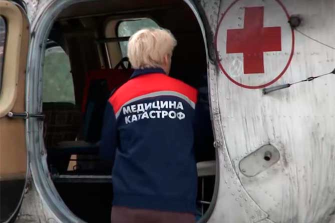 врач заходит в вертолет