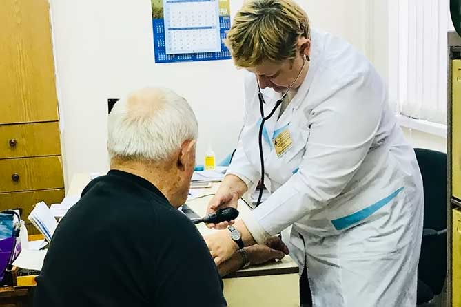 врач измеряет артериальное давление пациента