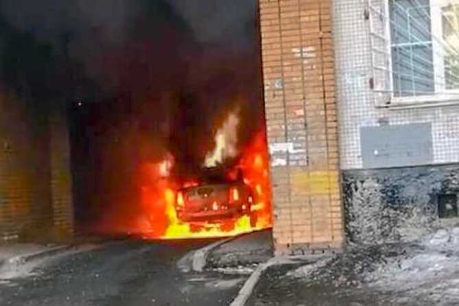 горит автомбиль в арке жилого дома
