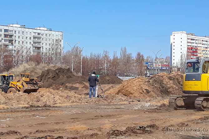 производит разметку на стройке