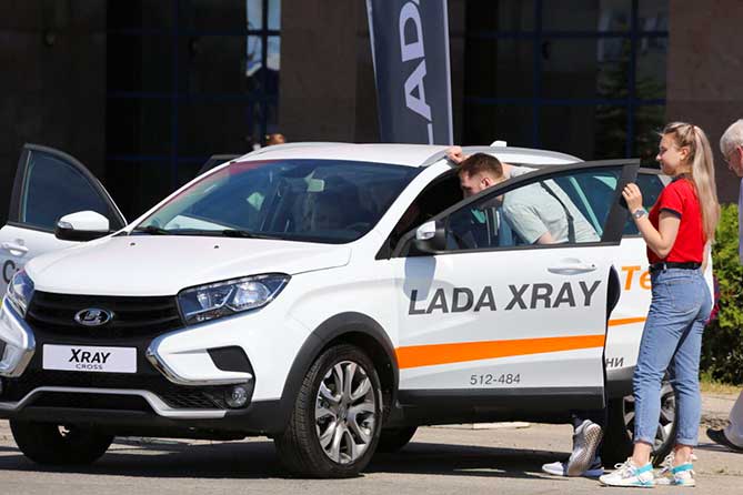 мужчина оасматривает автомобиль Лада Икс Рэй