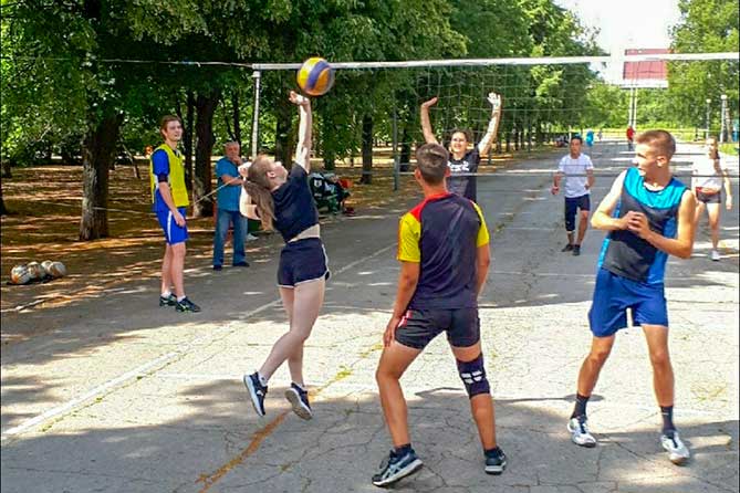 молодежь играет в волейбол в парке Победы