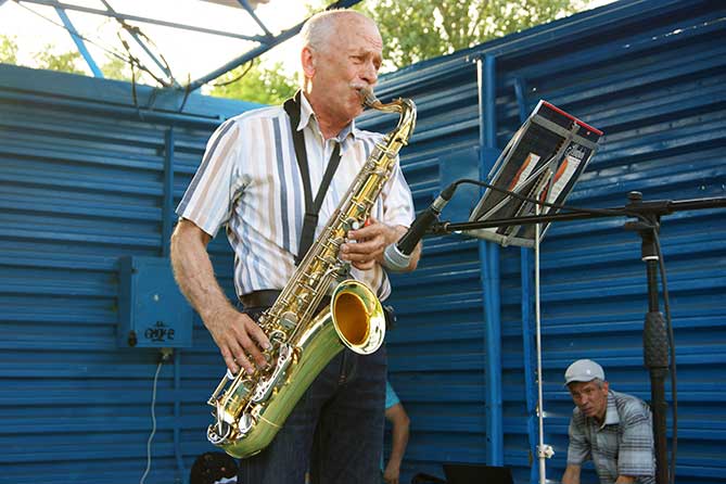 саксофонист выступает в парке Автозаводского района