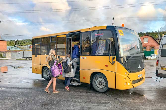школьники садятся в специализированный автобус для детей