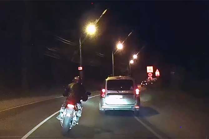 мотоциклист едет по дороге ночью