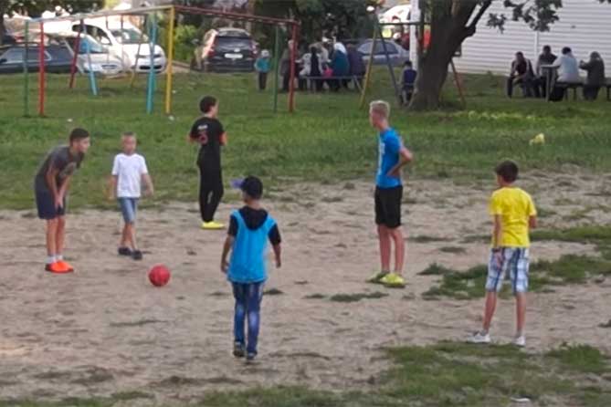 пацаны играют в футбол во дворе