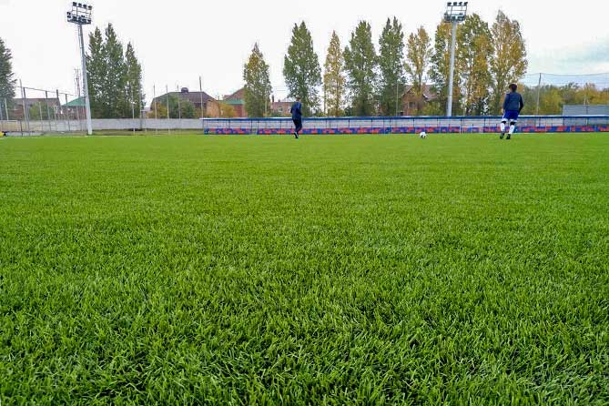 футболисты на футбольном поле сновым газономв академии имени Коноплева
