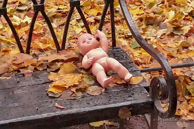 детская кукла лежит на лавке
