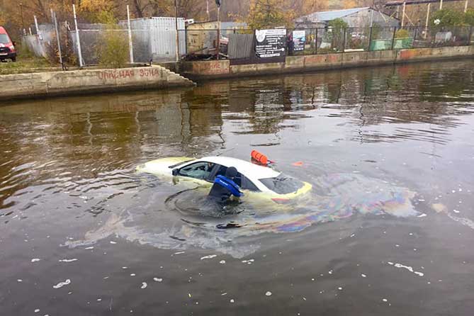 спасатель возле утонувшей машины