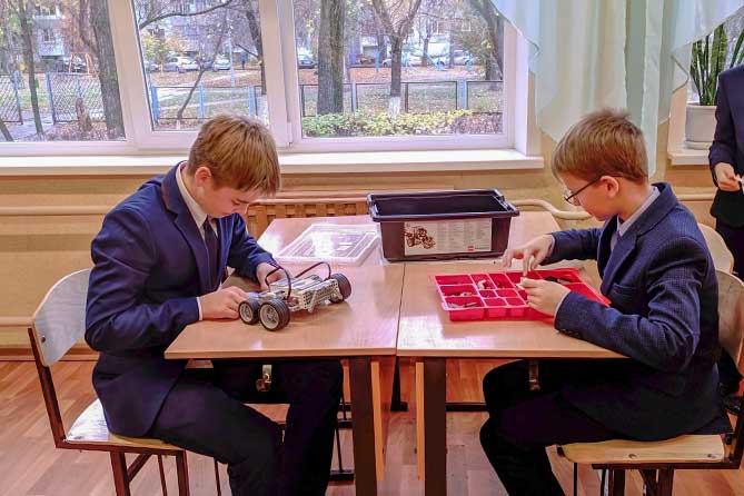 школьники собирают робота на уроке технологии