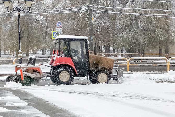 трактор чистит снег на тротуаре в Центральном районе
