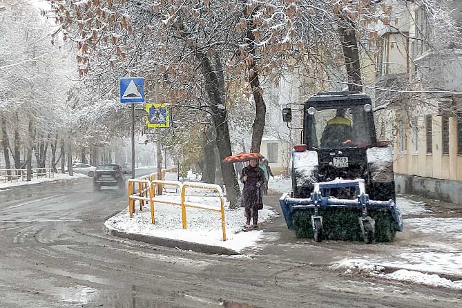трактор чистит снег на тротуаре 31 октября 2019 года