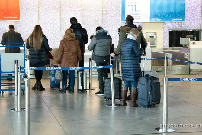 люди стоят в очереди на регистрацию в аэропорту