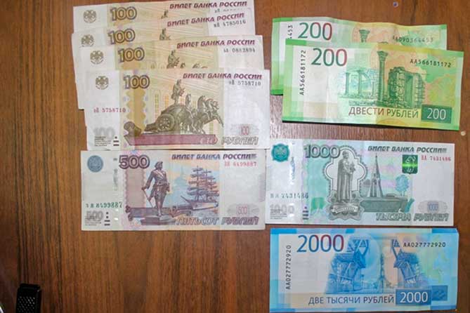 денежные купюры 100 500 200 рублей лежат на столе
