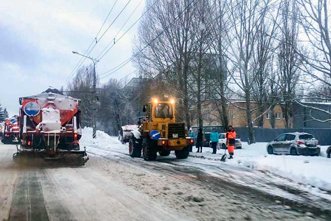 трактор убирает на снег на остановке на улице Баныкина