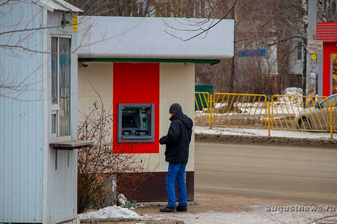 мужчина стоит около банкомата