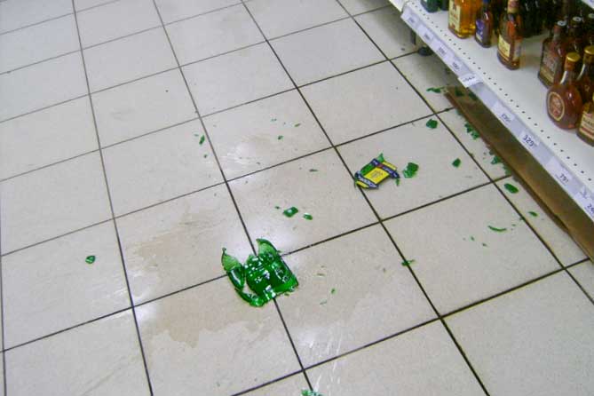 разбитая бутылка на полу в магазине