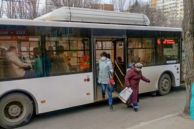 женщины выходят из автобуса в защитных масках