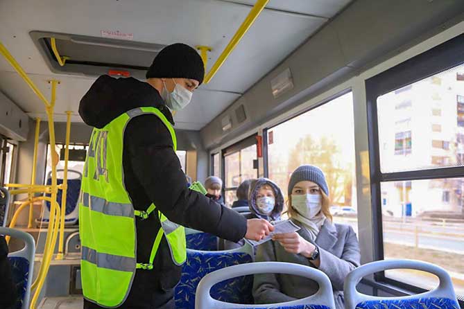 в салоне автобуса мужчина раздает памятки