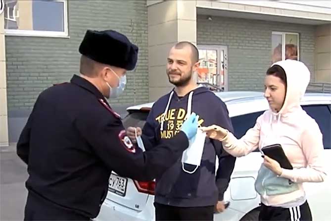 полицейский раздает маски