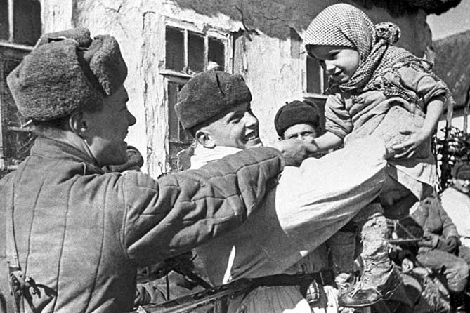 солдат держит девочку на руках