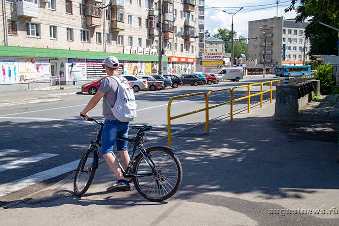 велосипедист стоит возле пешеходного перехода