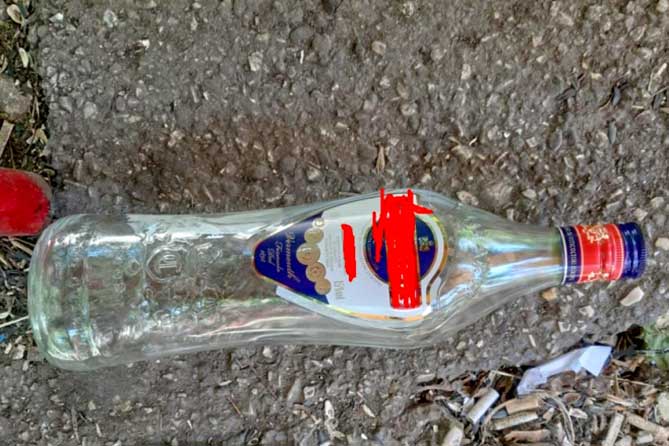 пустая стеклянная бутылка лежит на земле
