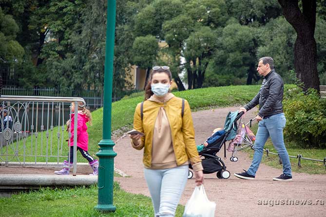 девушка идет в маске по парку