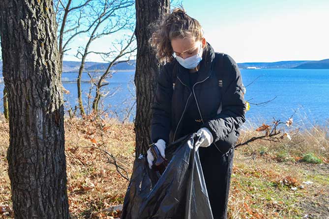 девушка убирает мусор на набережной Комсомольского района