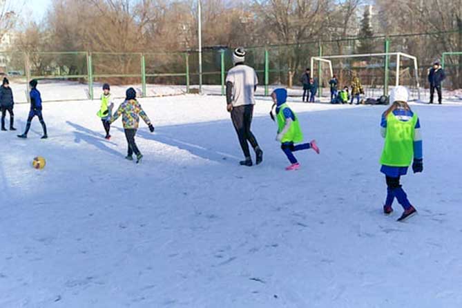 дети играют в футбол зимой
