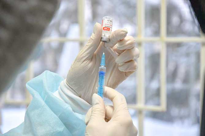 шприц с вакциной в руках медработника