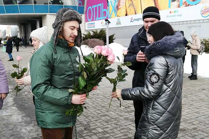мужчина дарит женщинам цветы на 8 марта