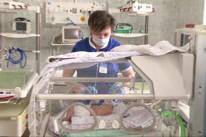 врач возле новорожденного в роддоме