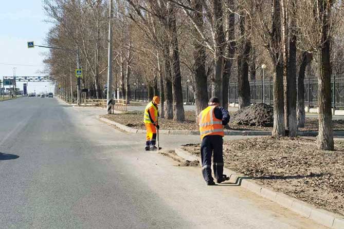 дорожные рабочие чистят прибордюрную территорию