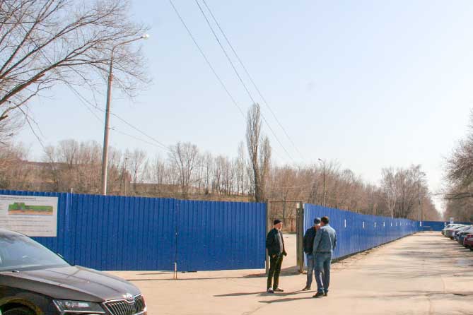строительный забор и рабочие на набережной Автозаводского района