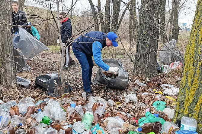 мужчинв убирают мусор на озере Пляжное