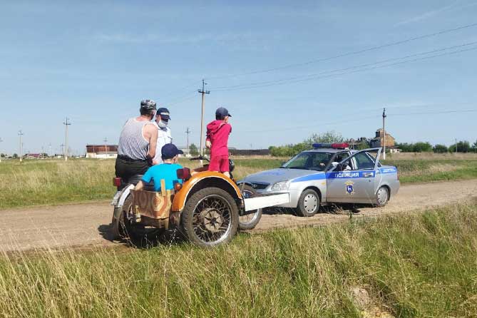 сотрудник ГИБДД проверяет документы у водителя мотоцикла