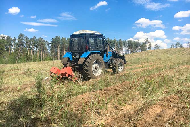 трактор проводит агротехнический уход леса