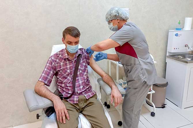 медработник проводит вакцинацию от коронавируса